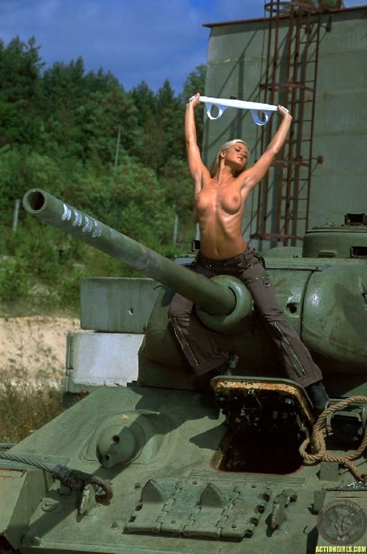 Голая на фоне военной техники